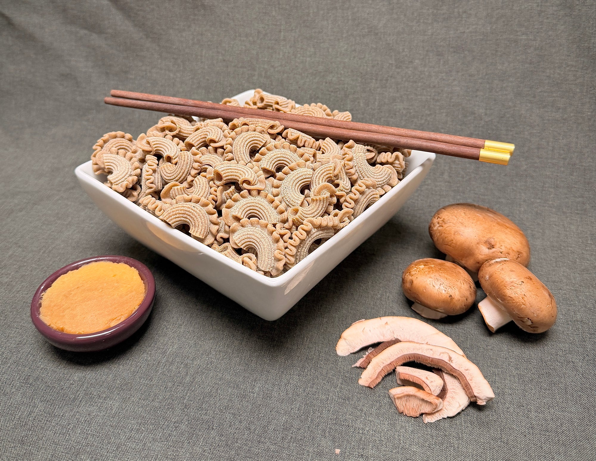 Dried rooster comb mushroom slices in a white bowl with tan curled pieces